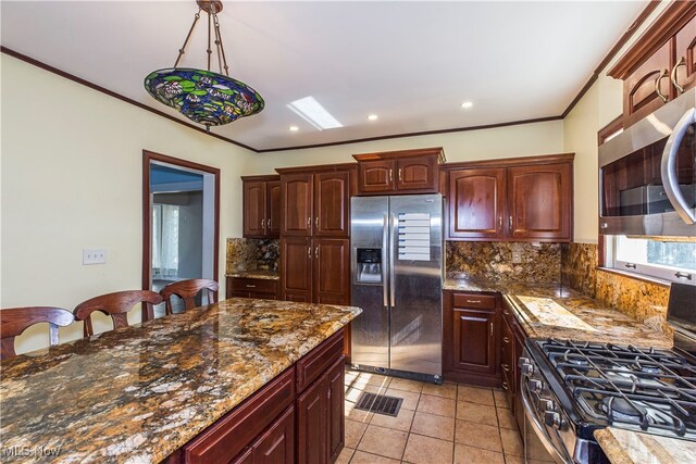 kitchen with light tile patterned flooring, hanging light fixtures, ornamental molding, tasteful backsplash, and stainless steel appliances