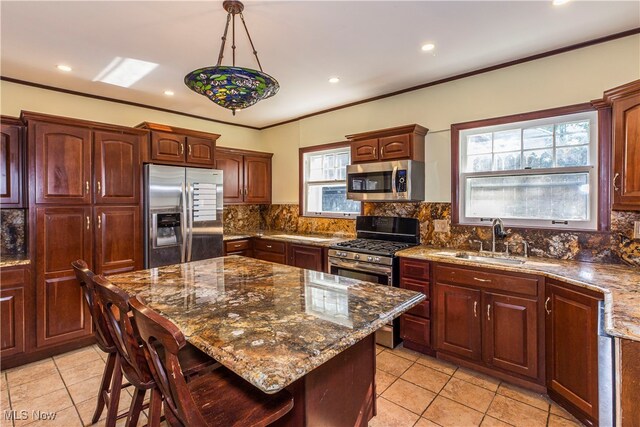 kitchen featuring stainless steel appliances, plenty of natural light, a breakfast bar area, and sink