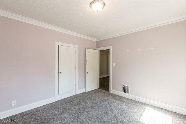 carpeted empty room featuring crown molding and a textured ceiling