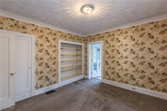 carpeted empty room with built in shelves and crown molding