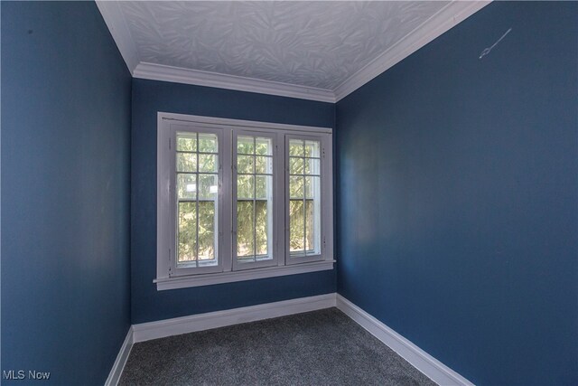 carpeted spare room featuring ornamental molding and lofted ceiling