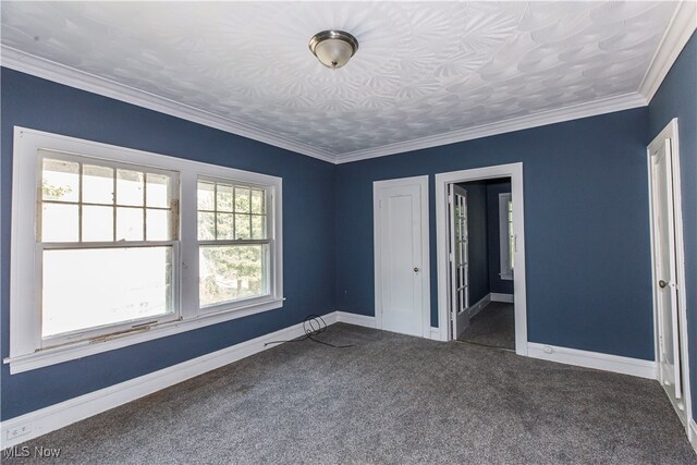 unfurnished bedroom featuring ornamental molding, dark colored carpet, and multiple windows