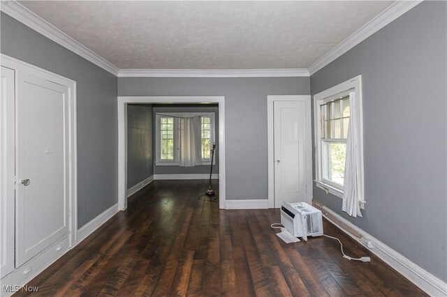 unfurnished room featuring plenty of natural light, ornamental molding, dark hardwood / wood-style flooring, and a textured ceiling