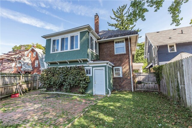 rear view of property featuring a lawn and a patio area