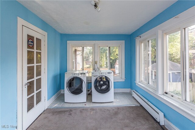 clothes washing area with washer and dryer, light colored carpet, and a baseboard radiator