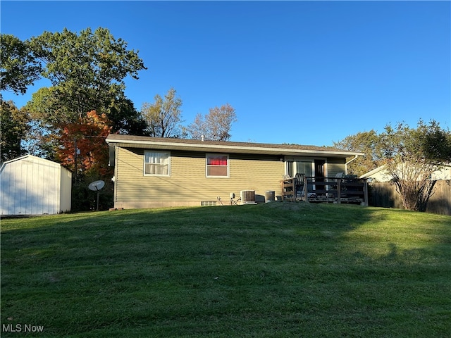 rear view of house featuring a yard and a shed