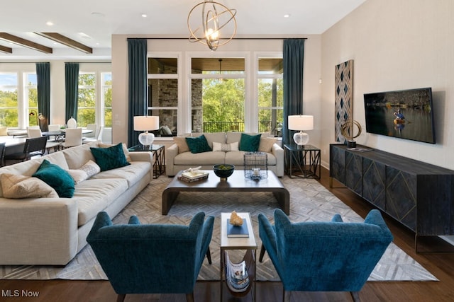 living room featuring beamed ceiling, hardwood / wood-style flooring, and a chandelier