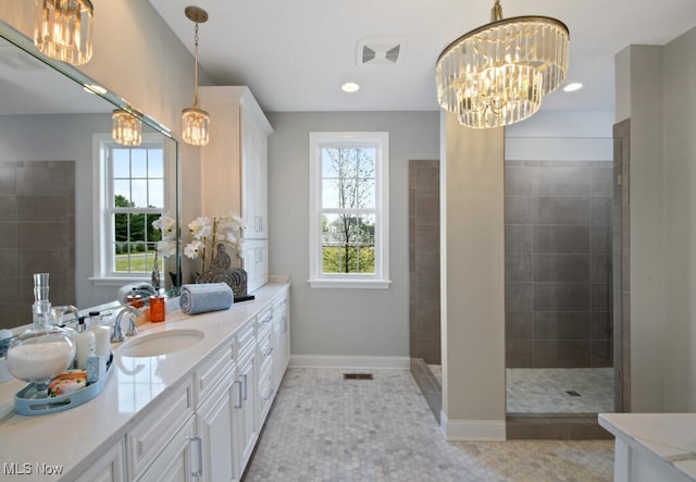 bathroom with tile patterned flooring, vanity, and tiled shower