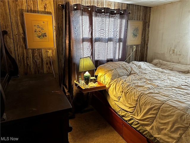 bedroom with wooden walls and carpet flooring