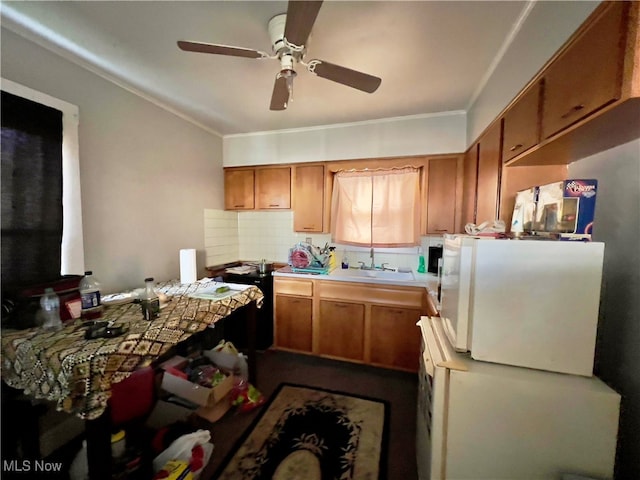 kitchen with ceiling fan, sink, crown molding, white refrigerator, and backsplash