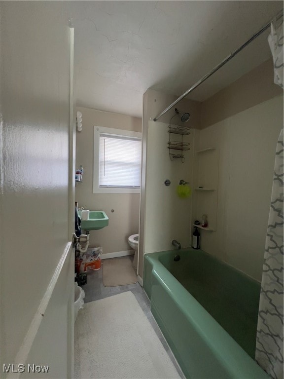 full bathroom featuring shower / bath combination with curtain, sink, and toilet