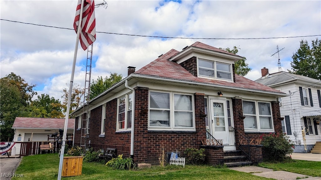 bungalow-style home with a front yard