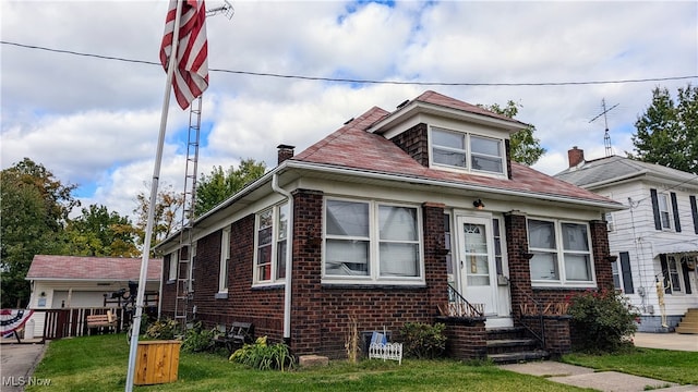 bungalow-style home with a front yard