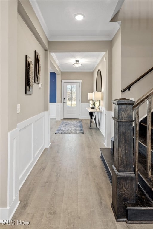 interior space featuring light wood-type flooring and crown molding