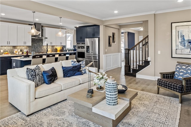 living room featuring ornamental molding and light hardwood / wood-style flooring