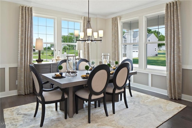dining space featuring ornamental molding, wood finished floors, and a chandelier