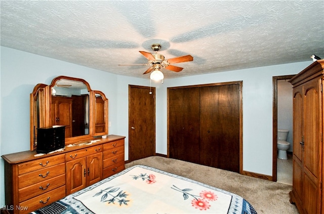 carpeted bedroom featuring ceiling fan, a closet, connected bathroom, and a textured ceiling