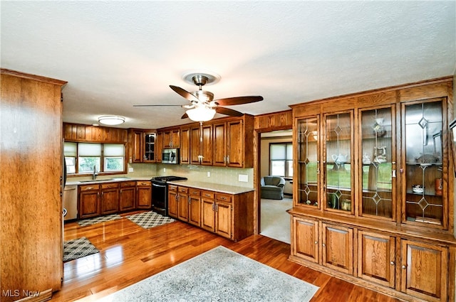 kitchen with ceiling fan, sink, a textured ceiling, appliances with stainless steel finishes, and dark hardwood / wood-style floors