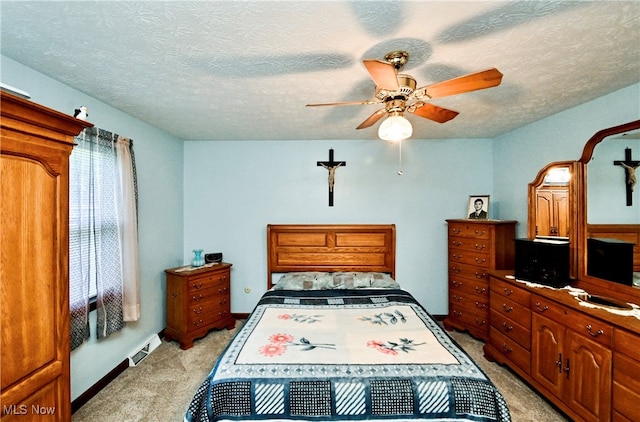 carpeted bedroom with ceiling fan and a textured ceiling