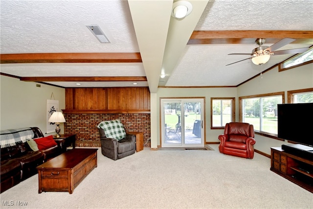 carpeted living room with ceiling fan, vaulted ceiling with beams, and a textured ceiling