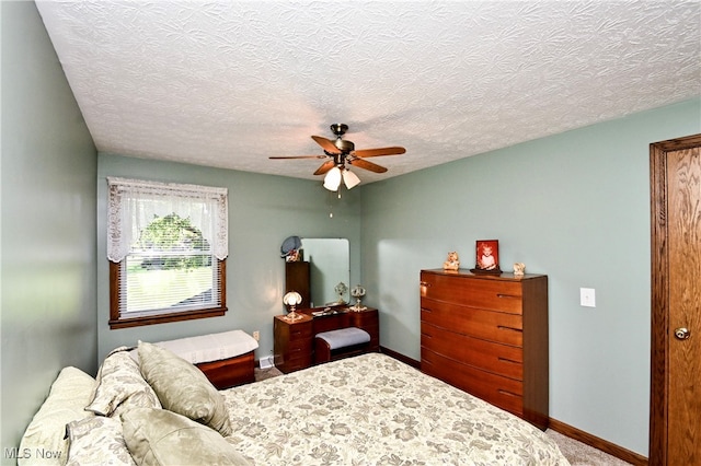 bedroom with ceiling fan and a textured ceiling