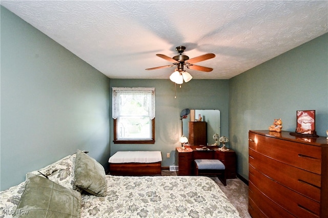 carpeted bedroom featuring ceiling fan and a textured ceiling