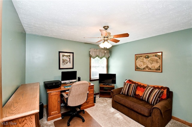 office area with light carpet, ceiling fan, and a textured ceiling