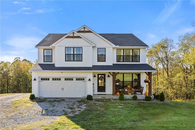 view of front of home with a garage, a porch, and a front lawn