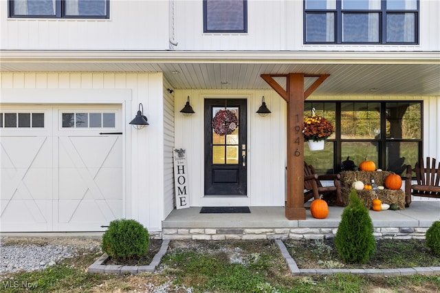 doorway to property featuring a porch and a garage