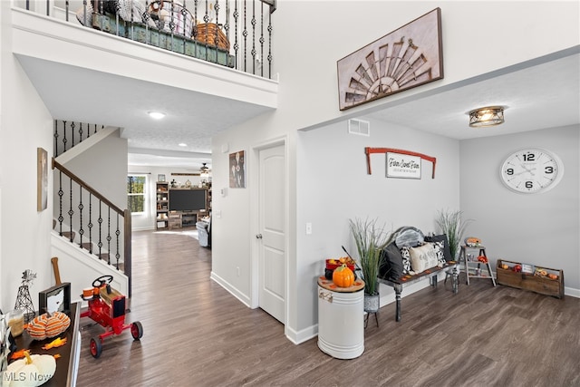 foyer entrance featuring dark wood-type flooring, a textured ceiling, and ceiling fan