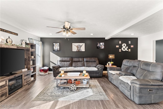 living room with wood-type flooring, a textured ceiling, and ceiling fan