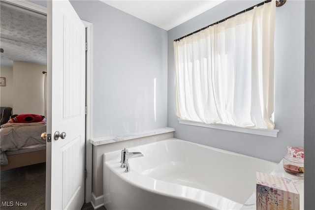 bathroom with a bathing tub and a textured ceiling