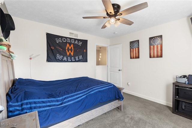 carpeted bedroom featuring ceiling fan and a textured ceiling