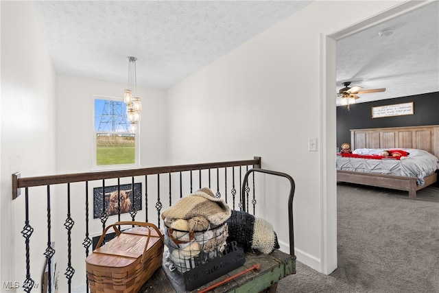 hallway featuring carpet flooring, a chandelier, and a textured ceiling