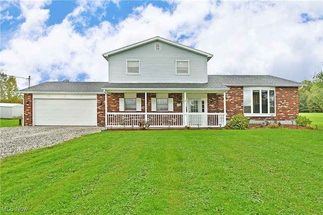 view of front of house with a front yard, a garage, and a porch