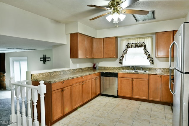 kitchen with appliances with stainless steel finishes, sink, kitchen peninsula, and a wealth of natural light