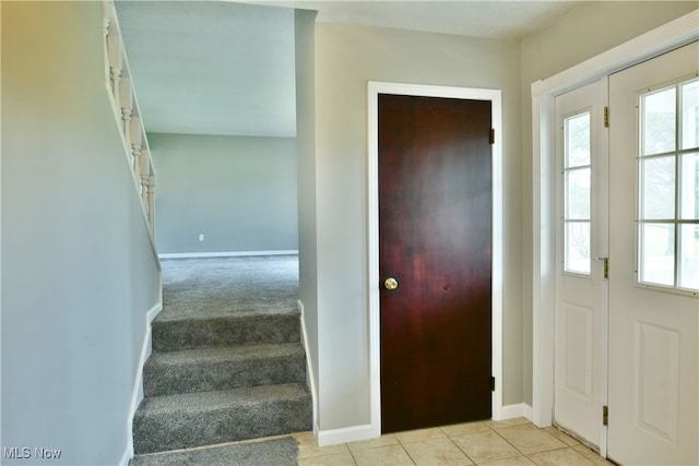 foyer entrance featuring light carpet