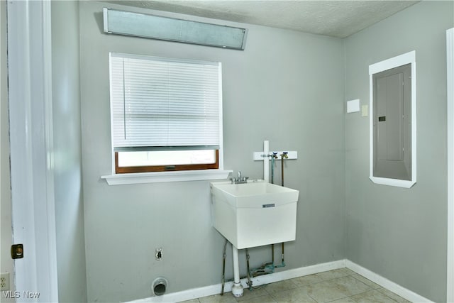 washroom featuring washer hookup, electric panel, light tile patterned flooring, a textured ceiling, and electric dryer hookup