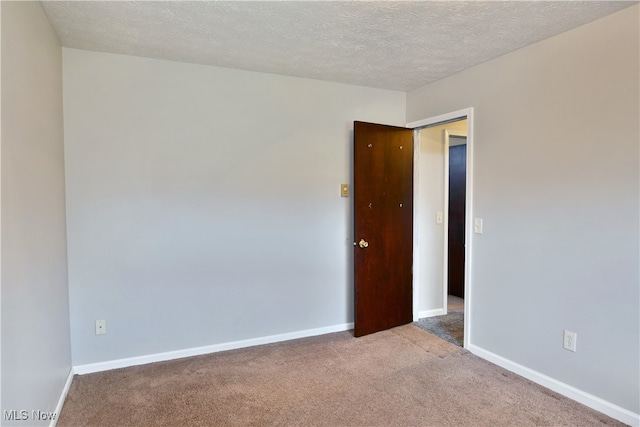 carpeted spare room with a textured ceiling