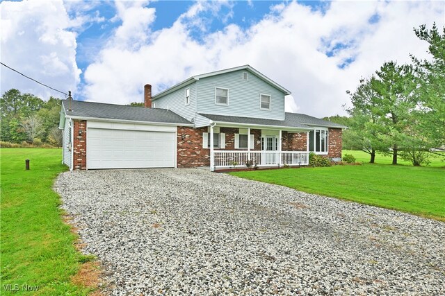 view of front of property featuring a garage, a porch, and a front yard