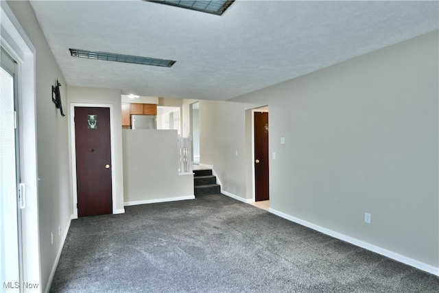 carpeted empty room with a textured ceiling and plenty of natural light