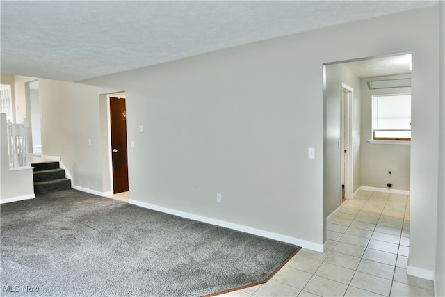 spare room with a textured ceiling and light carpet