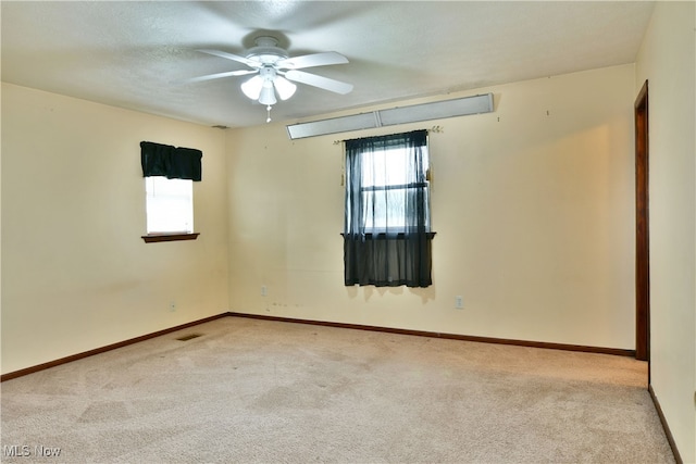 carpeted spare room featuring ceiling fan and a textured ceiling