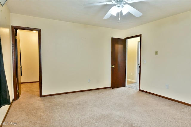 unfurnished room with light colored carpet and ceiling fan