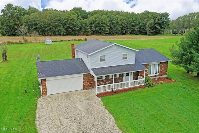 view of front of house with a garage, a front yard, and covered porch