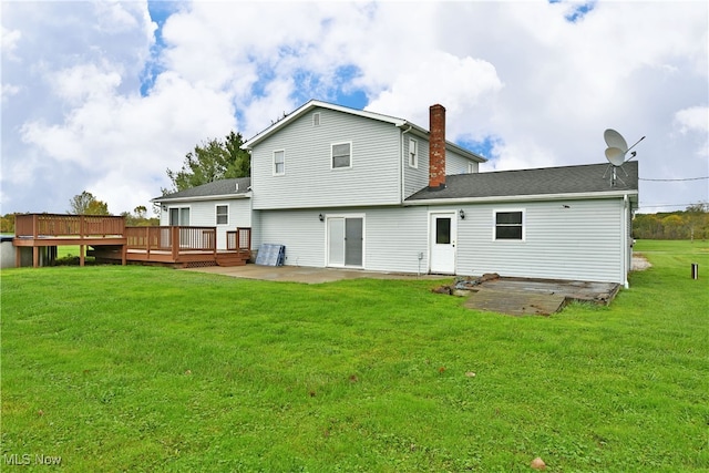 rear view of house featuring a yard, a wooden deck, and a patio