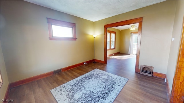 empty room featuring hardwood / wood-style floors, ceiling fan, and plenty of natural light