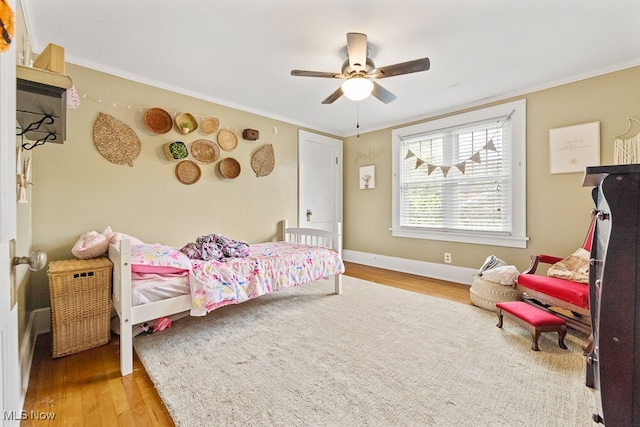 bedroom with ornamental molding, hardwood / wood-style floors, and ceiling fan