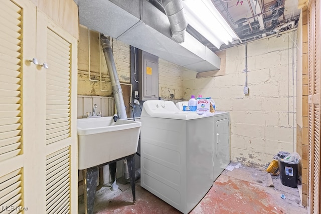 laundry area featuring electric panel, sink, and washer and clothes dryer