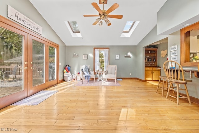 sitting room with lofted ceiling, french doors, light hardwood / wood-style floors, and ceiling fan